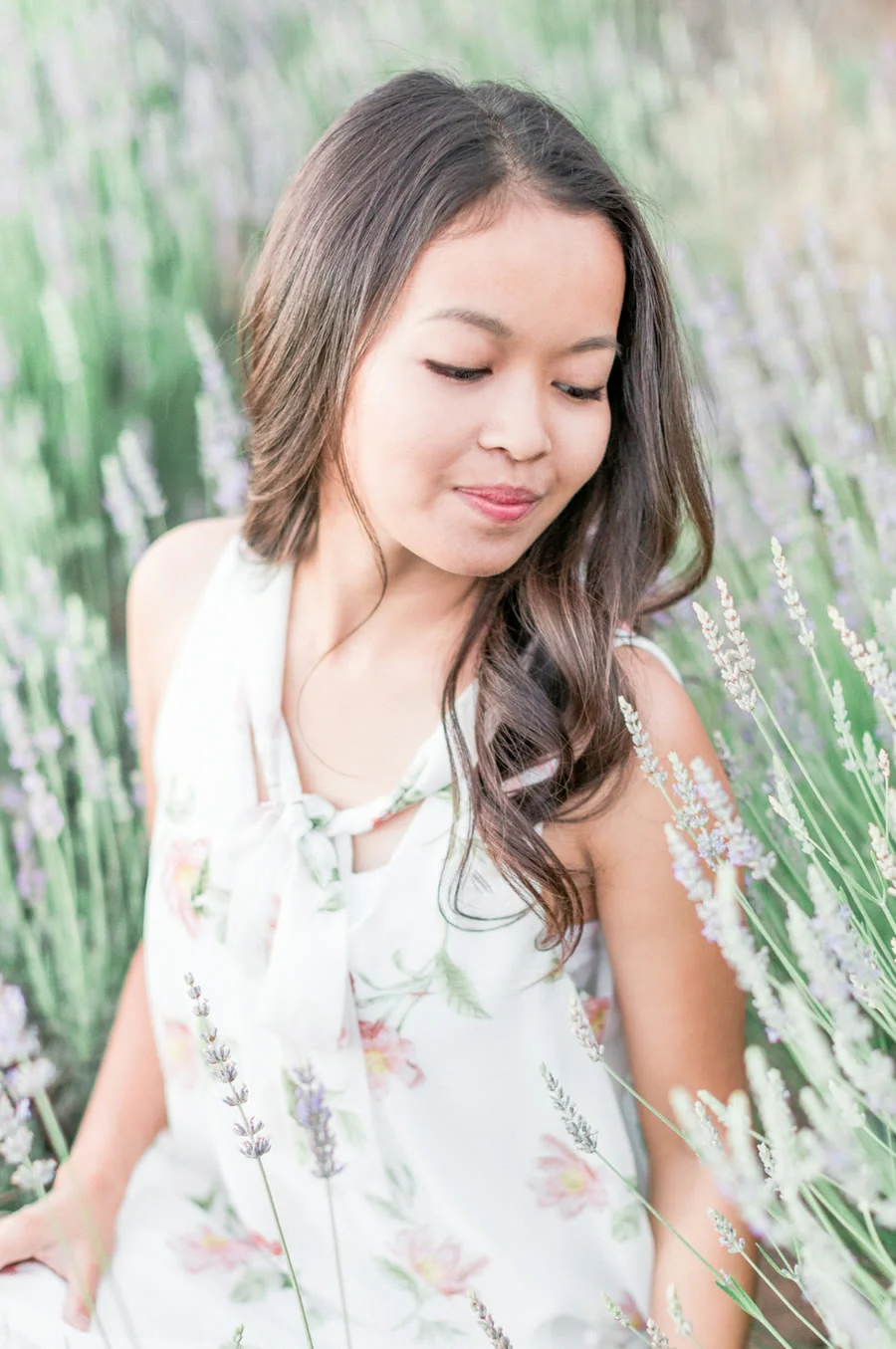Aiane Karla in a white dress standing in a lavender field, looking down